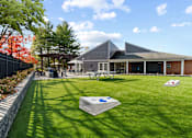 Thumbnail 25 of 41 - grassy area with cornhole boards and building in background at Westwinds Apartments, Annapolis MD