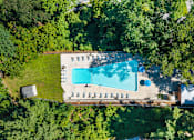 Thumbnail 17 of 20 - An aerial view of a swimming pool surrounded by trees.