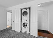 Thumbnail 7 of 20 - A white laundry room with a washer and dryer built into the wall.