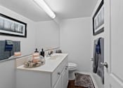 Thumbnail 14 of 20 - A bathroom with a toilet, sink, and a rug on the floor.
