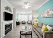 Thumbnail 17 of 42 - A living room with a fireplace and a couch at The Grand Reserve at Tampa Palms Apartments, Florida, 33647