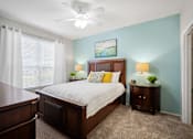 Thumbnail 23 of 42 - A bedroom with a bed, nightstands, and a ceiling fan at The Grand Reserve at Tampa Palms Apartments, Tampa, FL, 33647