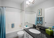 Thumbnail 25 of 42 - bathroom with shower and vanity with black countertop at The Grand Reserve at Tampa Palms Apartments, Tampa, 33647