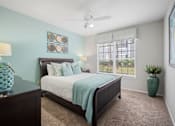 Thumbnail 20 of 42 - A bedroom with a bed, a ceiling fan, and a window with blinds at The Grand Reserve at Tampa Palms Apartments, Tampa, FL, 33647