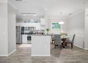 Thumbnail 16 of 42 - A modern kitchen with a dining table and chairs at The Grand Reserve at Tampa Palms Apartments, Florida, 33647
