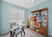 Thumbnail 7 of 42 - A room with a glass table and a wooden bookshelf at The Grand Reserve at Tampa Palms Apartments, Tampa, FL