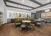 Thumbnail 20 of 31 - A modern dining area with a wooden floor and a green sofa at 1010 Dilworth Apartments, Charlotte, North Carolina