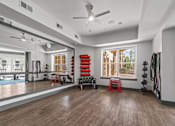 Thumbnail 22 of 31 - A spacious room with a ceiling fan, exercise equipment, and a view of the outdoors through large windows. at 1010 Dilworth Apartments, Charlotte, NC, 28204