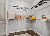 Thumbnail 10 of 31 - A white closet with a basket and a yellow box on the shelf at 1010 Dilworth Apartments, Charlotte 28204