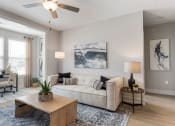 Thumbnail 4 of 15 - a living room with a couch and a ceiling fan at Bristol at New Riverside, Bluffton