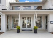 Thumbnail 15 of 15 - the front entrance of a building with glass doors and a sign on the sidewalk at Bristol at New Riverside, South Carolina