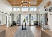 Thumbnail 14 of 15 - Leasing office with a circular chandelier and sliding glass doors at Bristol at New Riverside, Bluffton, 29910