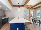 Thumbnail 12 of 15 - a kitchen with a large white counter top and a blue island at Bristol at New Riverside, South Carolina, 29910