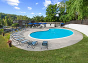 Thumbnail 10 of 12 - a pool with chairs and umbrellas around it at Brook View Apartments, Maryland