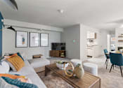 Thumbnail 12 of 23 - a living room and dining room with a couch and a table at Falls Village Apartments, Maryland
