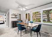Thumbnail 7 of 23 - a living room with a large window and a table with chairs at Falls Village Apartments, Maryland, 21209