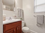 Thumbnail 5 of 19 - a bathroom with a sink toilet and a mirror at Donnybrook Apartments, Towson, MD