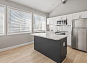 Thumbnail 17 of 20 - a kitchen with a large island and a stainless steel refrigerator at McDonogh Township Apartments, Owings Mills, MD, 21117