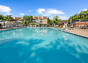 Thumbnail 2 of 20 - a large swimming pool with a building in the background at McDonogh Township Apartments, Owings Mills, MD