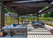 Thumbnail 20 of 31 - a patio with couches and tables and umbrellas at Padonia Village Apartments, Timonium