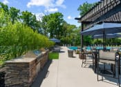 Thumbnail 21 of 31 - a patio with tables chairs and umbrellas and a pool at Padonia Village Apartments, Timonium, 21093