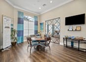 Thumbnail 39 of 42 - A living room with a wooden floor and a dining table with chairs at The Grand Reserve at Tampa Palms Apartments, Tampa, Florida