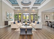 Thumbnail 37 of 42 - A modern living room with a large window and a wooden floor at The Grand Reserve at Tampa Palms Apartments, Tampa, FL