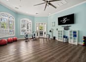 Thumbnail 36 of 42 - A room with a ceiling fan and exercise equipment at The Grand Reserve at Tampa Palms Apartments, Tampa, Florida