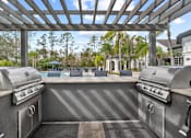 Thumbnail 29 of 42 - pergola with two grills overlooking pool at The Grand Reserve at Tampa Palms Apartments, Florida