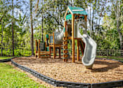 Thumbnail 32 of 42 - A playground with a green roofed structure and a grey slide at The Grand Reserve at Tampa Palms Apartments, Tampa, Florida