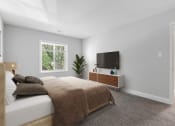 Thumbnail 9 of 31 - a bedroom with a large bed and a tv on the wall at Padonia Village Apartments, Timonium MD
