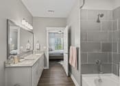 Thumbnail 3 of 38 - a bathroom with a shower and a sink and a mirror at Central Island Square, Daniel Island