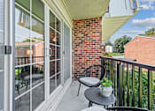 Thumbnail 14 of 25 - a patio with two chairs and a table on a balcony at Courthouse Square Apartments, Towson, MD