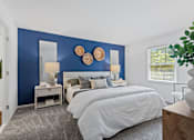 Thumbnail 5 of 25 - a bedroom with a bed and a blue wall at Courthouse Square Apartments, Towson, MD
