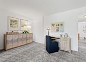 Thumbnail 9 of 25 - a living room with a blue chair and a desk at Courthouse Square Apartments, Maryland, 21286