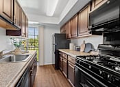 Thumbnail 8 of 25 - a kitchen with granite counter tops and black appliances at Courthouse Square Apartments, Towson, MD, 21286