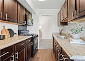 Thumbnail 3 of 25 - a kitchen with wooden cabinets and granite counter tops at Courthouse Square Apartments, Towson, 21286