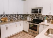 Thumbnail 9 of 30 - Kitchen with tile backsplash at Sycamore at Tyvola, Charlotte, North Carolina