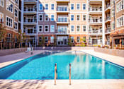 Thumbnail 10 of 18 - empty pool in front of an apartment building at Dartmoor Place at Oxford Square Apartments, Hanover, MD 21076