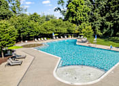 Thumbnail 16 of 25 - a swimming pool with chairs and umbrellas in a park-like setting with trees at Courthouse Square Apartments, Maryland