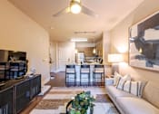 Thumbnail 3 of 26 - A living room with a television, couch, and a plant at The Edison Lofts Apartments, 27601