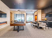 Thumbnail 15 of 26 - A room with a pool table, a fireplace, and a dining table at The Edison Lofts Apartments, Raleigh, NC