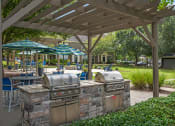 Thumbnail 27 of 41 - an outdoor kitchen with grills and umbrellas at Fortress Grove, Murfreesboro, TN, 37128