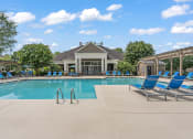 Thumbnail 22 of 41 - a resort style pool with lounge chairs and a clubhouse in the background at Fortress Grove, Murfreesboro, Tennessee