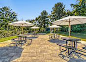 Thumbnail 17 of 23 - a patio with tables and umbrellas Falls Village Apartments, Baltimore MD