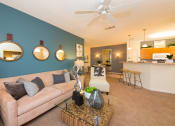 Thumbnail 18 of 41 - a living room with a blue accent wall and a tan couch at Fortress Grove, Murfreesboro, Tennessee
