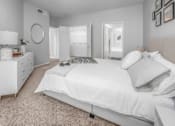 Thumbnail 10 of 22 - a white bedroom with a white bed and a white dresser at Henley Tampa Palms Apartments, Florida, 33647