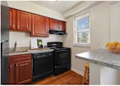 Thumbnail 13 of 19 - Kitchen with black appliances and breakfast bar at Donnybrook Apartments, Towson, MD, 21286