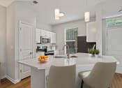 Thumbnail 1 of 41 - a kitchen with white cabinets and a white island with a bowl of fruit on it at Fortress Grove, Murfreesboro, TN