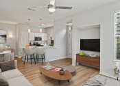 Thumbnail 3 of 41 - a spacious living room with a kitchen in the background and a ceiling fan in the foreground at Fortress Grove, Tennessee, 37128